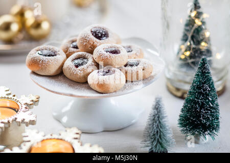 Biscotti di Natale con la marmellata riempimento sulla torta stand Foto Stock