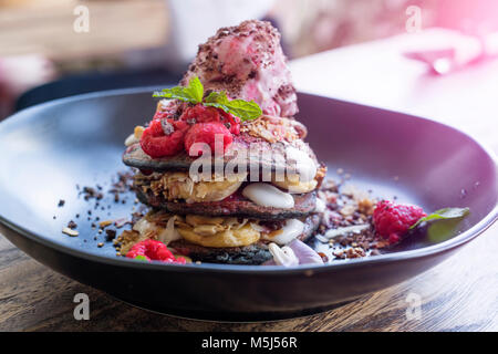 Decorate dessert rosa con lampone e foglie di menta Foto Stock