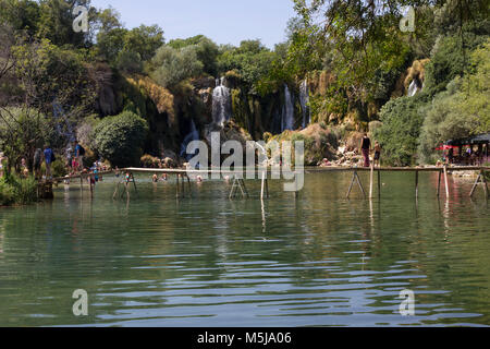 STUDENCI, BOSNIA ERZEGOVINA - 16 agosto 2017: cascate di Kravice in Bosnia Erzegovina, con un galleggiante ponte di legno Foto Stock