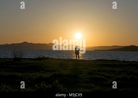 Una donna guarda al tramonto vicino a Oakland, CA Foto Stock