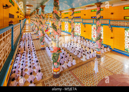 All'interno di Cao Dai Santa Sede tempio, provincia di Tay Ninh, Vietnam e meditando seguaci di Cao Dai religione Foto Stock