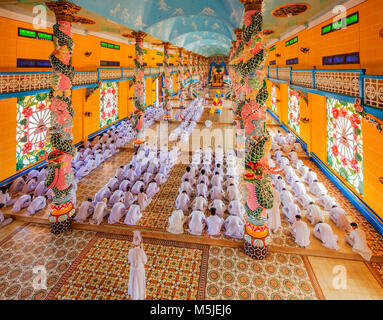 All'interno di Cao Dai Santa Sede tempio, provincia di Tay Ninh, Vietnam e meditando seguaci di Cao Dai religione Foto Stock