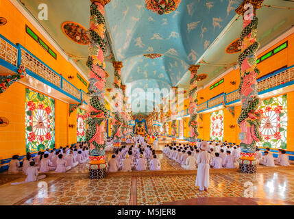 All'interno di Cao Dai Santa Sede tempio, provincia di Tay Ninh, Vietnam e meditando seguaci di Cao Dai religione Foto Stock