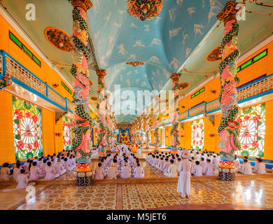 All'interno di Cao Dai Santa Sede tempio, provincia di Tay Ninh, Vietnam e meditando seguaci di Cao Dai religione Foto Stock