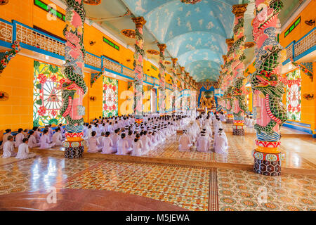 All'interno di Cao Dai Santa Sede tempio, provincia di Tay Ninh, Vietnam e meditando seguaci di Cao Dai religione Foto Stock