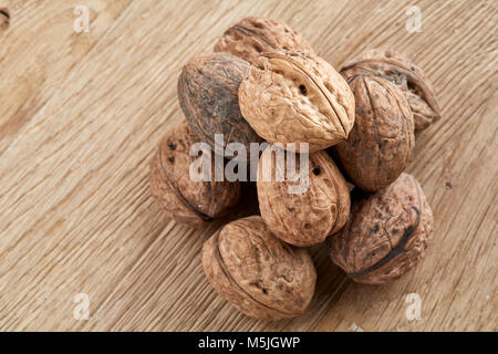 Una pila di dischi di gusci di noci impilati insieme su grigio chiaro tessuto cotone assorbente e isolate su legno rustico sfondo, spazio copia, fondale dept Foto Stock