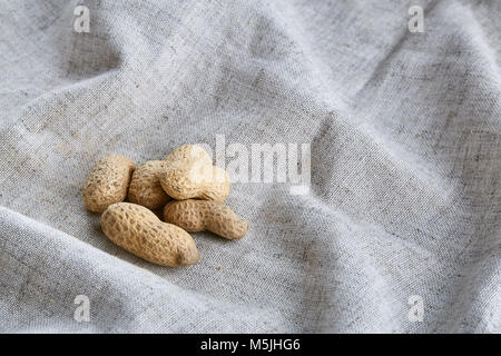 Vista superiore ritratto di close-up di cumulo di arachidi su grigio chiaro tessuto tovaglia in cotone o tovagliolo, qualche spazio copia, profondità di campo, focu selettiva Foto Stock