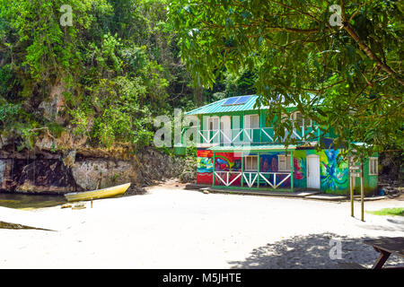 Caraibi colorato appartamento sulla spiaggia, giallo barca tra piante tropicali sulla sabbia bianca Foto Stock