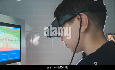 Oftalmologia - bambino ragazzo controlla gli occhi con occhiali stereo e monitor Foto Stock