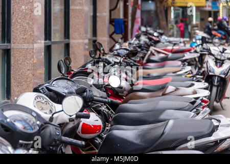 Un sacco di scooter parcheggiato lungo un sentiero di Hanoi, Vietnam Foto Stock
