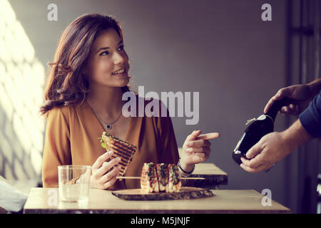 Bella donna di mangiare un club sandwich Foto Stock