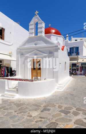 MYKONOS, Grecia - 23 Maggio 2017: una vista del tipico greco chiesa edificio sulla piazza con negozi nella città di Mykonos. Isole Cicladi, Grecia Foto Stock