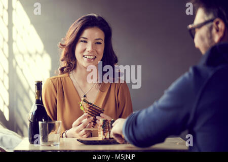 Bella donna di mangiare un club sandwich Foto Stock