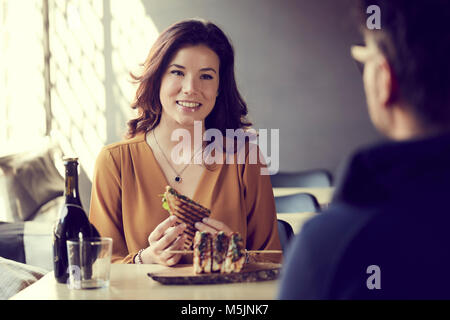 Bella donna di mangiare un club sandwich Foto Stock