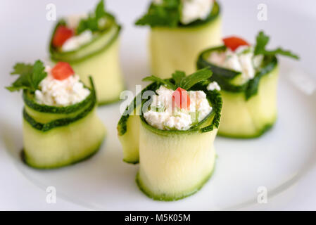 Rotoli di zucchine ripiene di formaggio e erba cipollina e la paprica rossa. Foto Stock