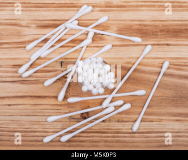 Doppio organico fine orecchio di cotone e portare i tamponi, germogli su legno sfondo vintage Foto Stock