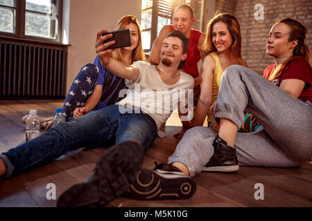 Danza, sport e cultura urbana concetto - gruppo di ballerini sorridenti tenendo selfie sullo smartphone Foto Stock