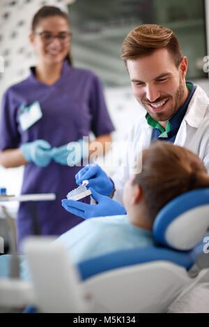 Dentista mostra al paziente giovane correttamente la spazzolatura dei denti sul modello di denti della ganascia Foto Stock