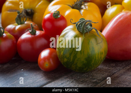 Pomodori colorati in legno rustico sfondo. Foto Stock
