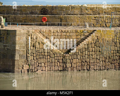 A V o a Y di granito a forma di gradini di pietra nel porto Mousehole parete, Mousehole, Cornwall, Regno Unito Foto Stock