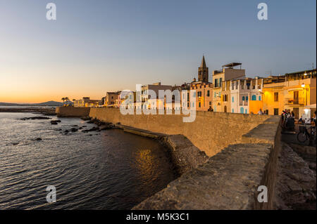 Lungomare della città costiera di Alghero dopo il tramonto, Sardegna, Italia Foto Stock