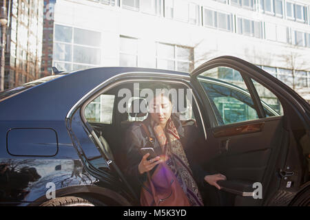 Giovani asiatici business donna uscendo di auto di servizio limousine Foto Stock