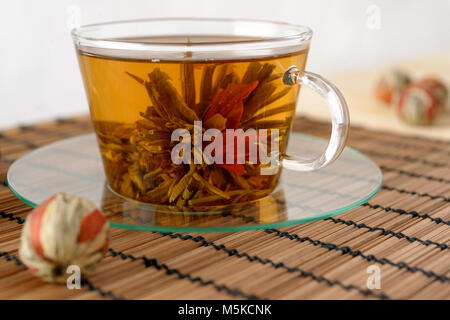 Tazza di tè verde con giglio rosso fiore Foto Stock