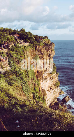 Il tramonto è visto attraverso il mare da un tempio sulla scogliera in Uluwatu, Bali Foto Stock