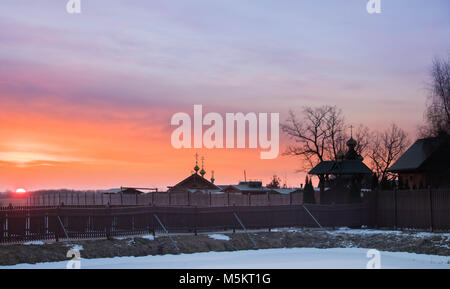 Sunrise contro ortodossi sourenden monastero dai campi congelato, canne e nevoso al di fuori a est della Polonia vicino ai confini Bielarus Foto Stock