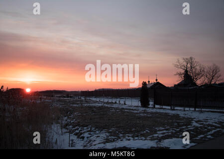 Sunrise contro ortodossi sourenden monastero dai campi congelato, canne e nevoso al di fuori a est della Polonia vicino ai confini Bielarus Foto Stock