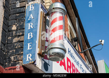 Tradizionale in rosso e bianco barbieri pole al di fuori degli uomini parrucchieri Foto Stock