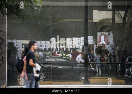 Caracas, Venezuela. 24 Febbraio, 2018. La protesta si vede dalla riflessione di un edificio commerciale.Il Foro delle ONG Penale Penale (Forum), effettuata una attività di strada per la liberazione dei prigionieri politici e la domanda di giustizia per le persone che sono morte durante le proteste dell'anno 2014/2017. Più di 300 persone sono in carcere per protestare contro il governo di nicolas maturi e più di 200 hanno perso la loro vita Credito: R CAMACHO 24022018-14.jpg/SOPA Immagini/ZUMA filo/Alamy Live News Credito: ZUMA Press, Inc./Alamy Live News Credito: ZUMA Press, Inc./Alamy Live News Foto Stock