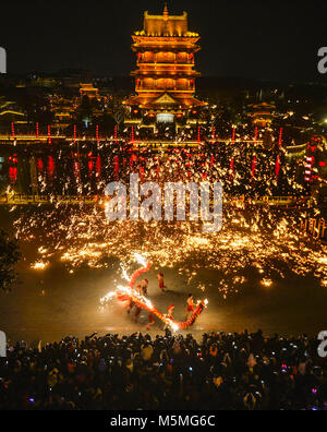 (180225) -- PECHINO, febbraio 25, 2018 (Xinhua) -- i turisti di guardare un fire dragon dance in una doccia di ferro fuso a Tai'erzhuang, est della Cina di Provincia di Shandong, Feb 17, 2018. Cina postato una crescita a due cifre delle entrate del turismo durante la settimana di capodanno nuovo anno lunare vacanza, i dati ufficiali hanno mostrato mercoledì. Il settore del turismo ha raccolto 475 miliardi di yuan (circa 75 miliardi di dollari) delle entrate, fino 12,6 percento da ultimo anno di vacanza, secondo la Cina amministrazione nazionale del turismo (CNTA). Alcuni 386 milioni di viaggi di turisti sono stati realizzati fino a 12,1 percento da ultimo anno di vacanza, LA CNTA sai Foto Stock