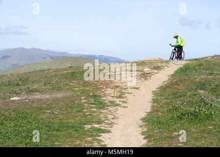 Un uomo si prende una pausa dalla mountain bike al Sierra Vista in San Jose. Foto Stock
