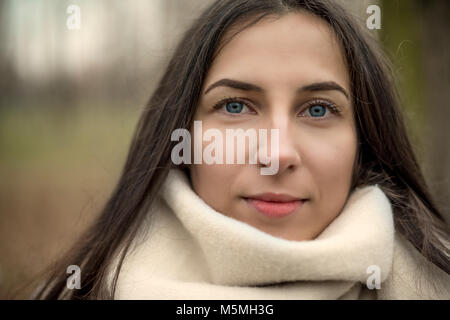 Ritratto di un elegante piuttosto giovane donna con gli occhi blu nella moda autunno guardando la telecamera. Outdoor ritratto preso nel parco. Foto Stock
