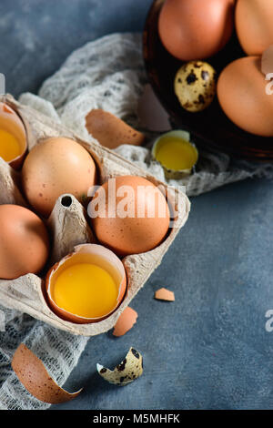 Tuorlo d'uovo in un guscio d'uovo close-up. Rosolare le uova di gallina in un vassoio di cartone con copia spazio. Cucinare con gli ingredienti freschi del concetto. Foto Stock