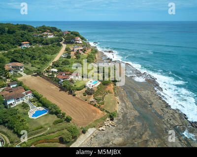 Le case di lusso sulla costa dell'oceano pacifico la linea aerea vista drone sulla giornata di sole Foto Stock