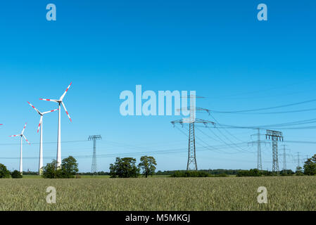 Linee aeree e delle turbine a vento in una giornata di sole visto in Germania Foto Stock