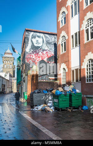 Traboccante di rifiuti raccoglitori di immondizia in una strada laterale nel centro di Cardiff. Foto Stock