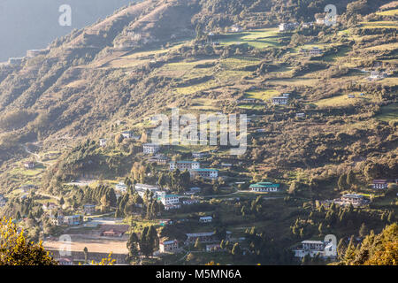 Trongsa, Bhutan. Case sulla collina, nel tardo pomeriggio. Foto Stock