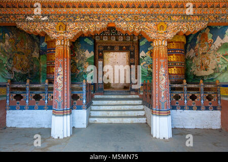 Trongsa, Bhutan. Ruote della preghiera ingresso di fianco a un cortile interno in Trongsa Dzong (Monastery-Fortress). Foto Stock