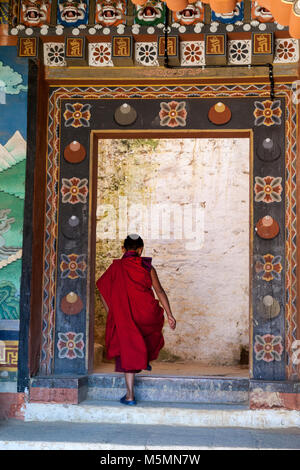 Trongsa, Bhutan. Giovane Monaco buddista di entrare in un cortile interno in Trongsa Dzong (Monastery-Fortress). Foto Stock