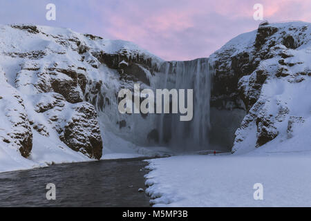 Skogafoss cascata in un inverno di sunrise, Islanda Foto Stock