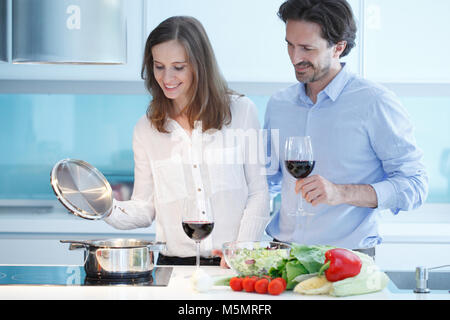 Ritratto di un giovane con un bicchiere di vino rosso durante la cena di cucina Foto Stock
