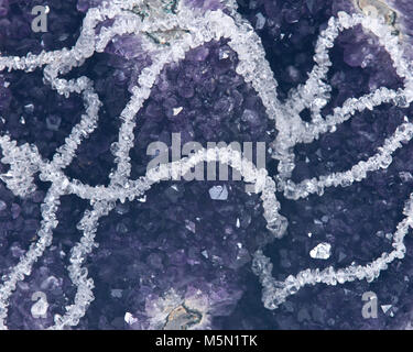 Quarzo trasparente Tumbled Chips collana presentati su ametista geode isolati su sfondo bianco Foto Stock