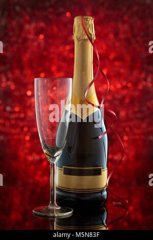 Bicchiere di champagne e rosso della decorazione di luci. Foto Stock