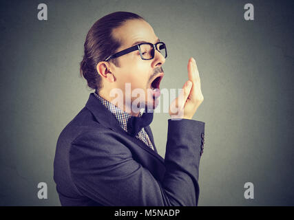 Giovane uomo controllo del respiro con la sua mano gesto di prova. Foto Stock