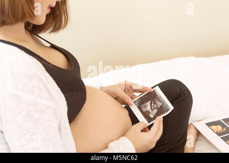 Felice donna incinta tenendo l'immagine ad ultrasuoni Foto Stock