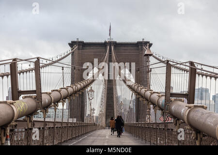 La gente che camminava sul percorso pedonale attraverso il ponte di Brooklyn. New York City Manhattan downtown con grattacieli su East River panorama visto da Broo Foto Stock