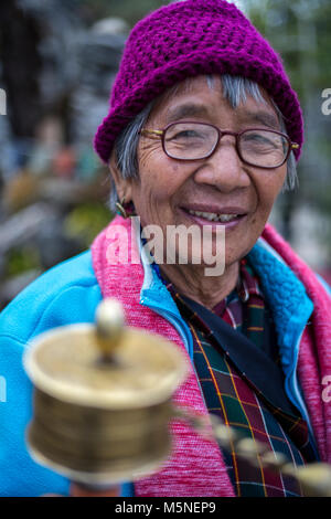 Thimphu, Bhutan. Adoratore con ruota di preghiera presso il National Memorial Chorten. Foto Stock